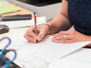 Ingrid maakt een jaarrekening aan het bureau